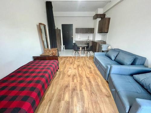 a living room with a blue couch and a wooden floor at Heven of Chilovski in Filipów