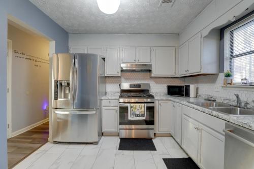 a kitchen with white cabinets and stainless steel appliances at Lithonia Home, 5 Mi to Panola Mountain State Park in Lithonia