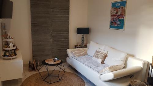 un salon avec un canapé blanc et une table dans l'établissement Appartement climatisé proche Gare et Centre-Ville, à Sète