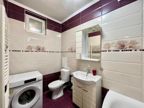 a bathroom with a toilet sink and a washing machine at Apartament central în Chișinău! in Chişinău