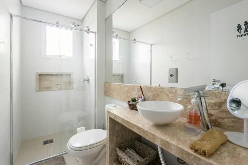 La salle de bains est pourvue d'un lavabo, de toilettes et d'une douche. dans l'établissement Ap de frente para o mar Canto da Vila Imbituba, à Imbituba