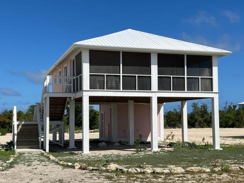 a large house on the beach with a porch at Barbuda Cottages in Codrington Village