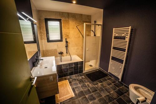 une salle de bain avec une baignoire, un lavabo et une douche dans l'établissement VILLA PISCINE MIROIR ET JACUZZI, à Saint-Bauzille-de-Montmel