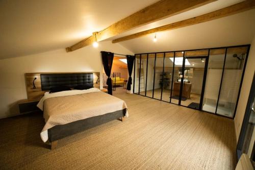 une chambre avec un grand lit dans une pièce dans l'établissement VILLA PISCINE MIROIR ET JACUZZI, à Saint-Bauzille-de-Montmel