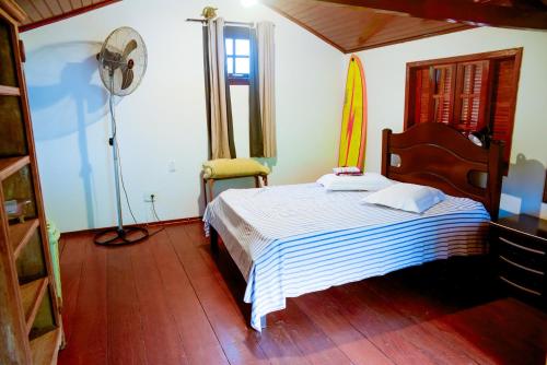 a bedroom with a bed and a surfboard on the wall at Casa a 220m da Praia de Boicucanga-Sao Sebastiao in São Sebastião