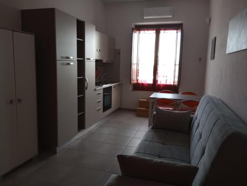 a living room with a couch and a kitchen at Casa Vacanze di Alex in Càbras