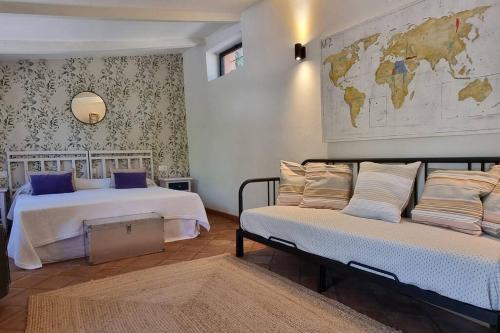 een slaapkamer met 2 bedden en een kaart aan de muur bij Bonita casa rural con jardín y terraza privado in Jimena de la Frontera