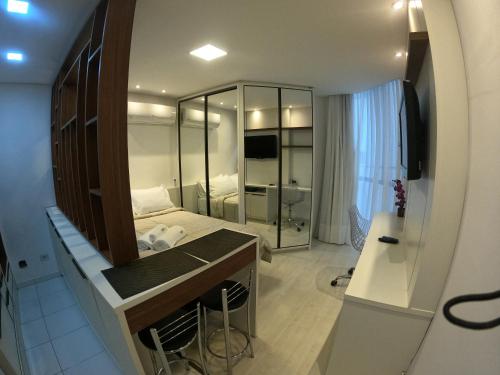 um pequeno quarto com uma cama e um lavatório em Studio novíssimo e aconchegante no Juvevê. em Curitiba