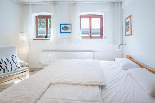 Am Schlosspark في هوسوم: غرفة نوم بيضاء بسرير كبير ونوافذ