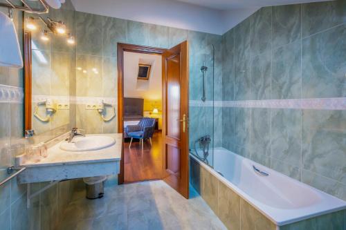 a bathroom with a sink and a bath tub at Hotel Verdemar in Ribadesella