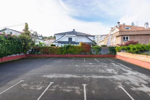 an empty parking lot with a house in the background at Hotel Verdemar in Ribadesella