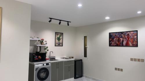 a kitchen with a washing machine in a room at GOLD DuBA in Ḑubā