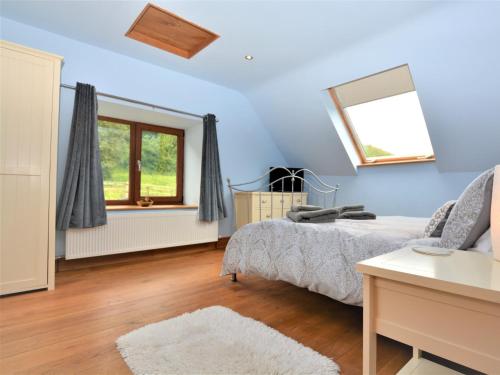 a bedroom with blue walls and a bed and a mirror at 4 Bed in Kidwelly CWRTY in Kidwelly