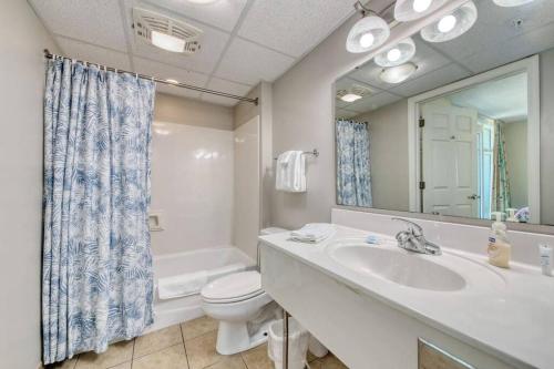 La salle de bains est pourvue d'un lavabo, de toilettes et d'un miroir. dans l'établissement Amazing Oceanfront Home HS 4th Floor, à Myrtle Beach