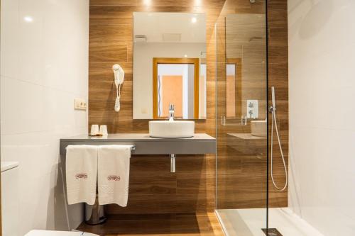 W łazience znajduje się umywalka i lustro. w obiekcie Pensión Casa Alvarito w mieście Portonovo