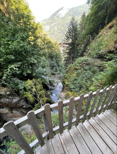a wooden bench sitting on a bridge over a river at Mazot Agora & Spa Family Trip - Chalet Ouest R+1 in Salvan