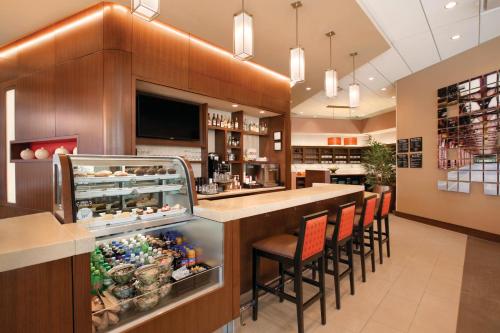 a restaurant with a bar with stools and a counter at Hyatt Place Chicago-South/University Medical Center in Chicago