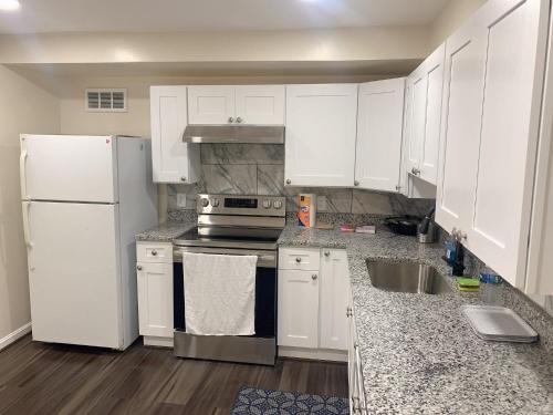 uma cozinha com electrodomésticos brancos e armários brancos em Sweet bedroom located central of downtown em Baltimore