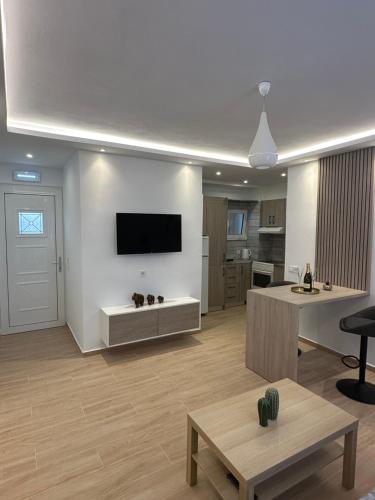 ロードス・タウンにあるHella apartmentの壁に薄型テレビが取り付けられたリビングルーム