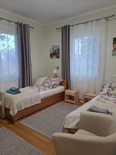 um quarto com 2 camas, uma cadeira e uma janela em Lena apartment - Lena two bedroom apartment em Vecsés