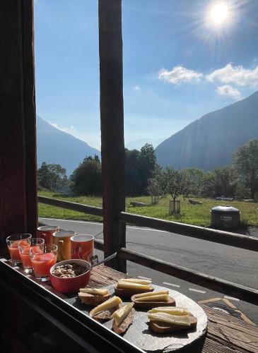 a tray with food and drinks on a table with a view at Mazot Agora & Spa Family Trip - Chalet Ouest R+1 in Salvan