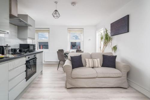 a living room with a couch and a kitchen at Trendy 2bed apartment in Brick Lane - 3rd Floor in London