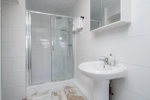 a white bathroom with a sink and a shower at Trendy 2bed apartment in Brick Lane - 3rd Floor in London