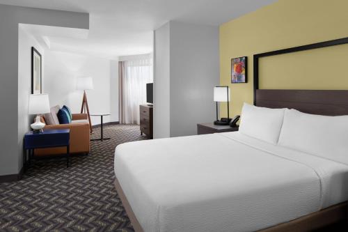 ein Hotelzimmer mit einem großen Bett und einem Stuhl in der Unterkunft Residence Inn White Plains Westchester County in White Plains