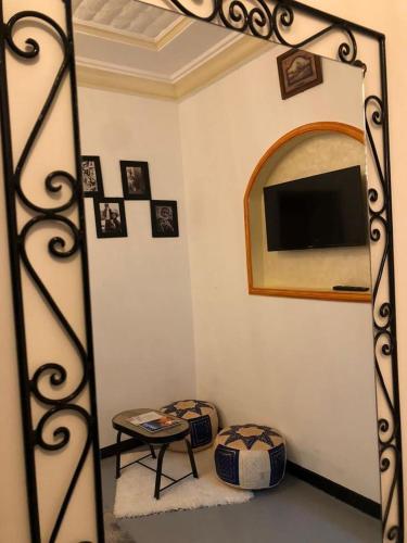 sala de estar con espejo y TV en Gîte d'étape Tamaloute, en Bou Drarar