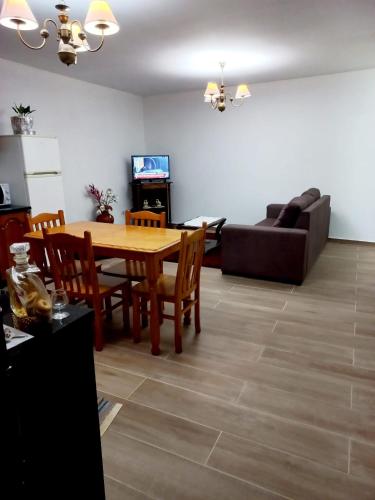 a living room with a wooden table and a couch at Casa Jardim in Ponta do Pargo