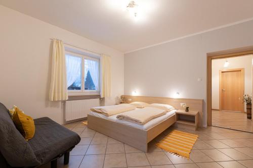 une chambre avec un lit, un canapé et une fenêtre dans l'établissement Appartements Margit, à Vipiteno