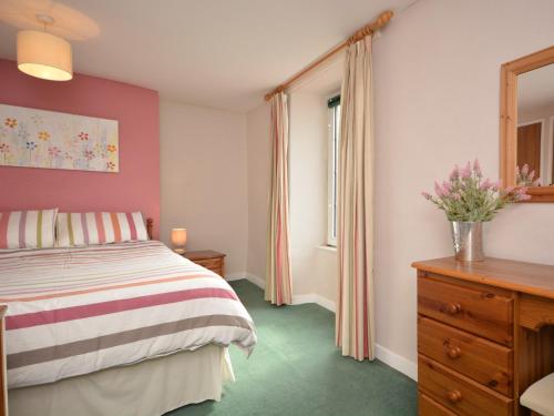 a bedroom with a bed and a dresser and a window at 2 Bed in Wells VESPE in Wells