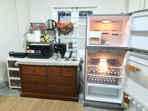 an open refrigerator with its door open in a kitchen at 3 BR Cozy Home Skytrain View BKK in Bangkok