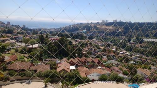 a view of a town through a wire fence at Habitación Costa Reñaca in Viña del Mar