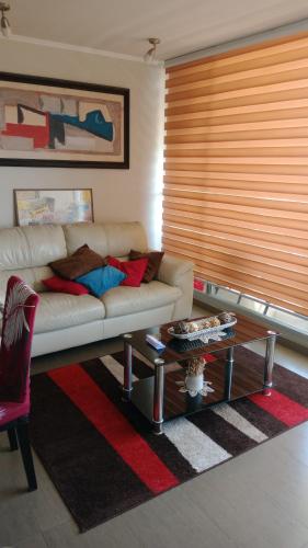 a living room with a couch and a coffee table at Habitación Costa Reñaca in Viña del Mar