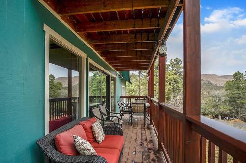 a porch with a couch and chairs on a house at Hummingbird Haven - Charming Ruidoso Retreat home in Ruidoso