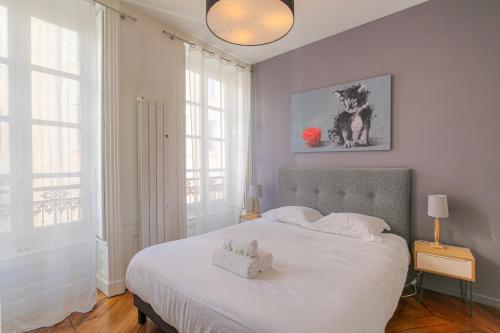 une chambre avec un lit avec deux animaux en peluche dessus dans l'établissement Caractère et Charmant en Hypercentre, à Lyon