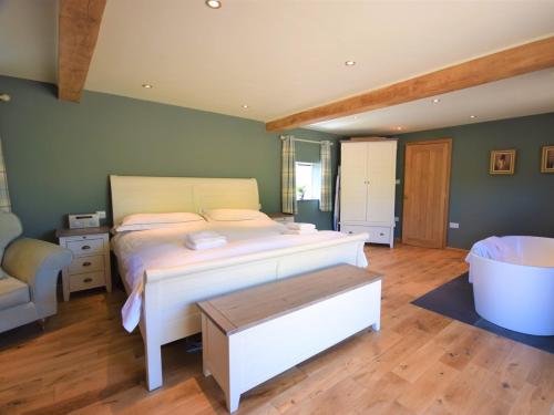 a bedroom with a large bed and a bath tub at 1 Bed in Croyde 75270 in Marwood