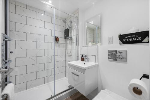 een witte badkamer met een douche, een toilet en een wastafel bij 1 BR, central Southampton, Stunning Apt by Blue Puffin Stays in Southampton