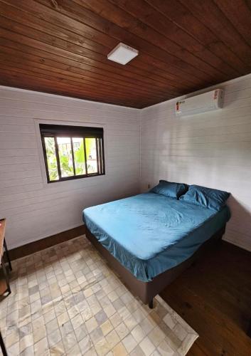 1 dormitorio con 1 cama en una habitación con ventana en Casa tranquila 500 metros da praia do campeche en Florianópolis