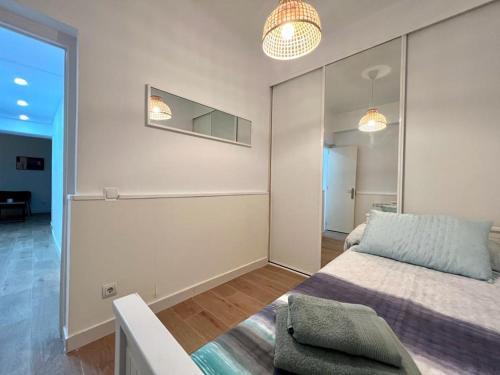una camera da letto con un letto e uno specchio a parete di Excelente piso en Chamberi! a Madrid