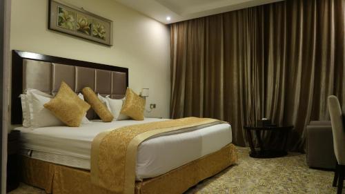 a hotel room with a large bed with gold pillows at فندق اللوتس in Najran