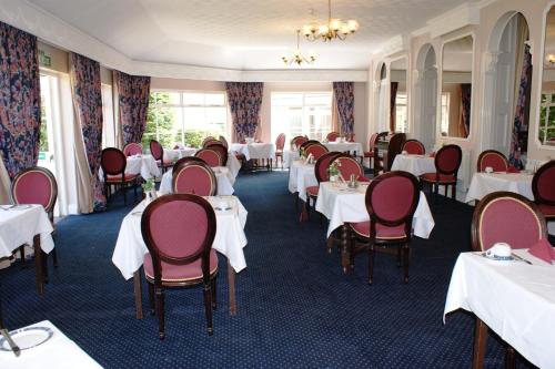 a room filled with tables and chairs filled with food at Grange Lodge Hotel in Saint Peter Port