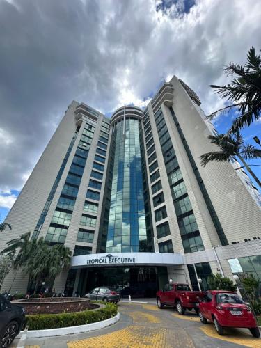 a large building with cars parked in a parking lot at 1111 Studio de Luxo com vista deslumbrante para o Rio in Manaus