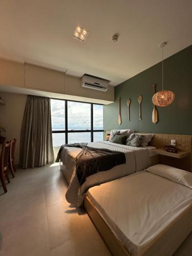 a bedroom with a large bed and a large window at 1111 Studio de Luxo com vista deslumbrante para o Rio in Manaus