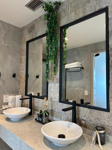 two sinks in a bathroom with a large mirror at Studio de Luxo com vista deslumbrante para o Rio in Manaus