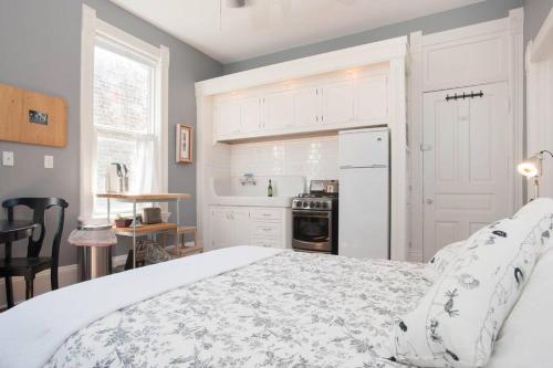 a white bedroom with a bed and a kitchen at iKlektik House // Robin in Chicago