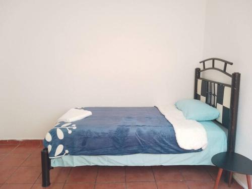 a bedroom with a black bed with a blue comforter at duplicado in Tlacote el Bajo