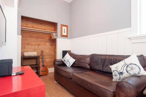 a brown leather couch in a room with a guitar at iKlektik House // Robin in Chicago