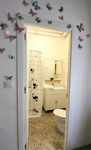 a bathroom with a toilet and butterflies on the wall at Dorado 2 in Barcelona